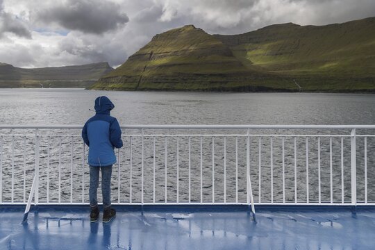 Girl standing at the railing of the ferry Norr&ouml;na, Smyril Line ship, during passage through the Faroe Islands, Faroe Islands, Denmark