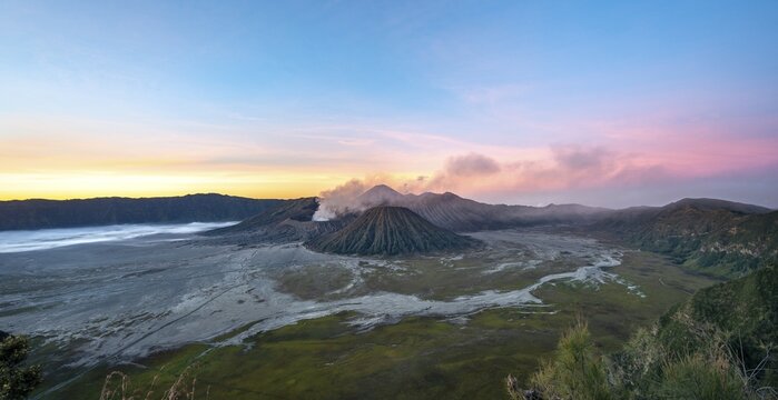Volcanic landscape at sunrise, smoking volcano Gunung Bromo, with Mt. Batok, Mt. Kursi, Mt. Gunung Semeru, Bromo-Tengger-Semeru National Park, Java, Indonesia