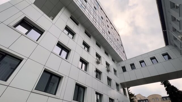 Modern Hospital Building with Ventilated Facade and Glass Patient Floors Viewed from Below | Sky Bridge Between Wings | Contemporary Medical Architecture Wide-Angle Bottom-Up View