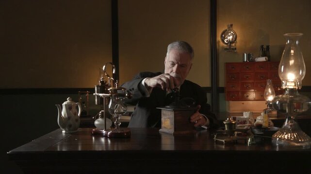 19th century businessman grinding coffee at his desk