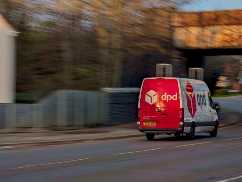 Leicester, England, UK - 26 November 2025: DPD delivery van driving on British road, courier service vehicle in motion, Mercedes Sprinter with DPD branding, logistics and transportation UK