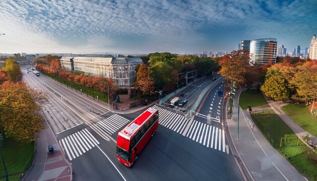 double decker city shuttle bus at an intersection with markings rides down the street aerial view