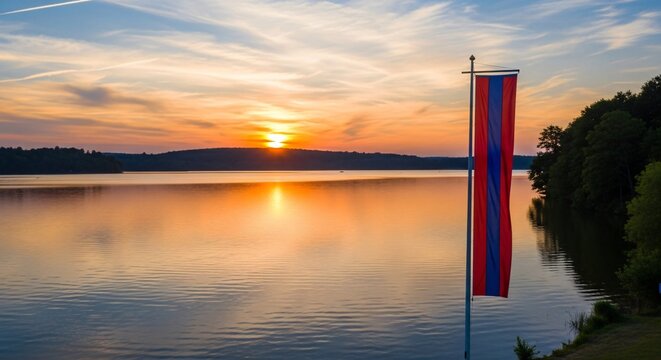 Drapeau de comm&eacute;moration au coucher du soleil sur un lac paisible, hommage solennel pour la Journ&eacute;e du Souvenir, atmosph&egrave;re de paix et de recueillement