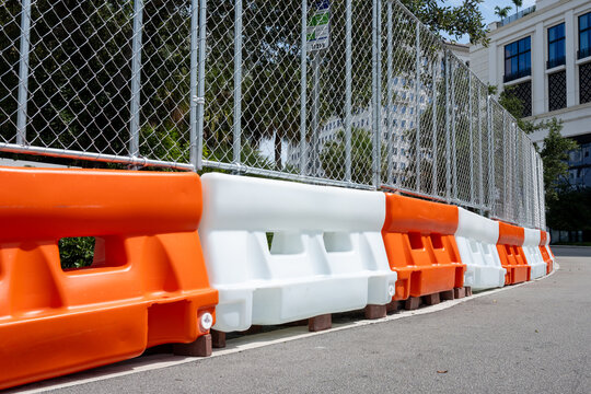 Road Construction Barriers and Chain Link Fence on Sunny Day
