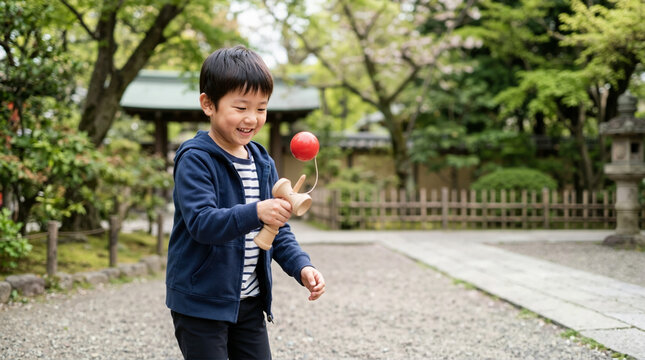 Smiling Japanese boy playing with a traditional wooden kendama toy outdoors. Asian child enjoying a cultural game in a garden setting