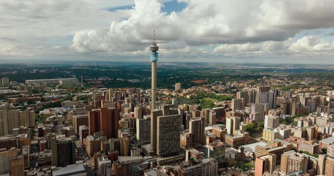 Epic establishing shot of Johannesburg , South Africa. Hillbrow Tower and the vast city skyline. Dramatic aerial urban landscape, dense architecture, and metropolitan horizon. 4K drone zoom out video