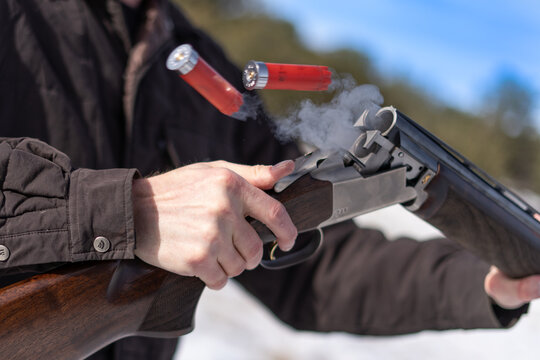 Red Shotgun Shells Ejecting From A Smoking Gun Barrel With Visible Trigger Detail