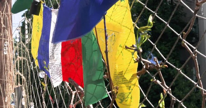 Colorful Buddhist flags hung on a wicker net at an outdoor cafe outside