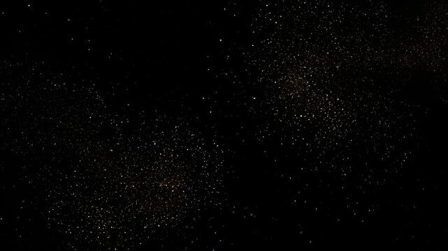 Dark background speckled with scattered golden particles