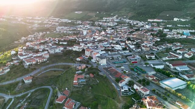 Aerial view of the Basilica Menor de Nossa Senhora da Assuncao and the historic town center with white houses and red roofs under bright sunlight in Torre de Moncorvo, Braganca, Portugal.