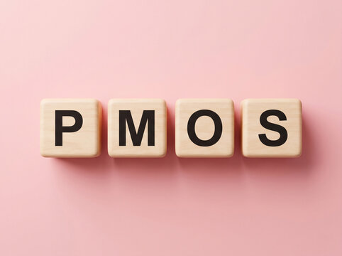wooden blocks spelling pmos on medical pink background for pcos endocrine metabolic disorder awareness concept