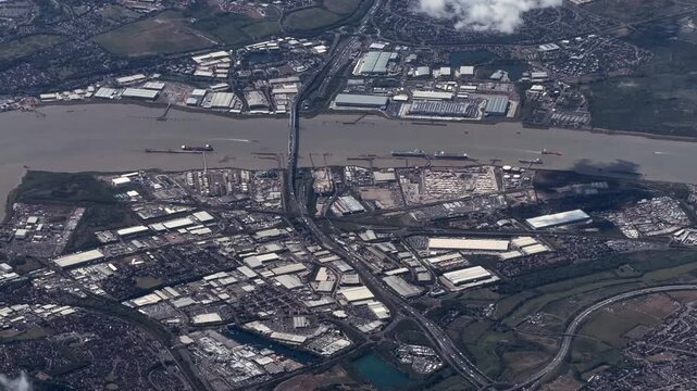 flying along River Thames in the Thurrock unitary authority, Essex, England with industrial areas around Purfleet-on-Thames and Dartford - 4k aerial video footage