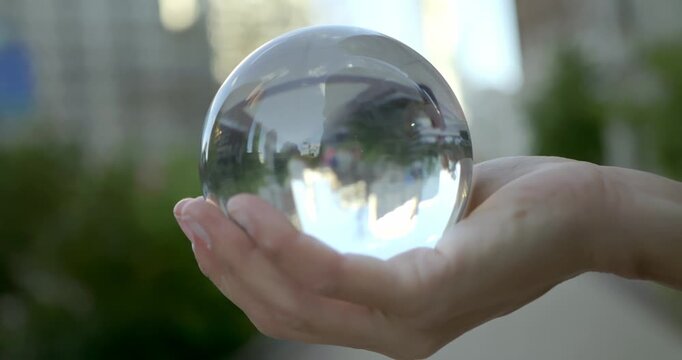 Hand Holding Crystal Ball Outdoors in Urban Setting