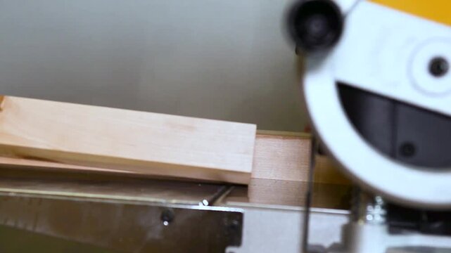 A wood plate passing through the thickness planer machine in a carpentry workshop. Woodworking process, furniture preparation, handmade craftsmanship, carpentry studio.