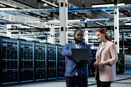 Brainstorming, infrastructure systems and engineering team in data center, managing uptime and efficiency. Upgrade enterprise networks hardware, device and teamworking colleagues in server room