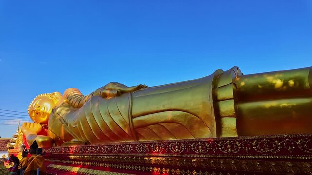 Beautiful reclining Buddha in Wat That Luang Tai, Vientiane, Laos. This sacred Buddhist statue shines in gold, attracting travelers seeking cultural heritage, spirituality, and iconic temple