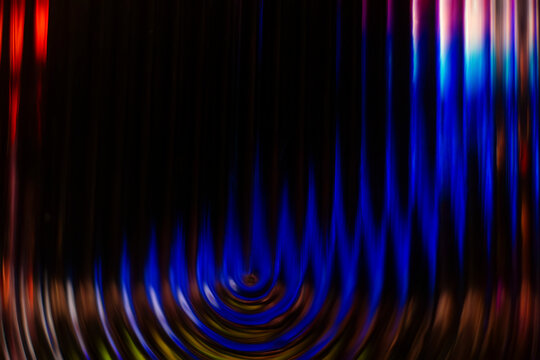 Dark abstract background with bright blue glowing concentric ripples at the base