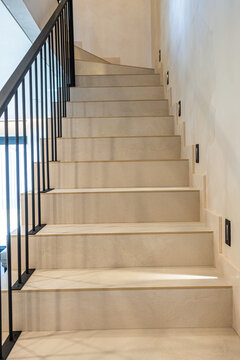 Low angle view of modern stone staircase with black railing