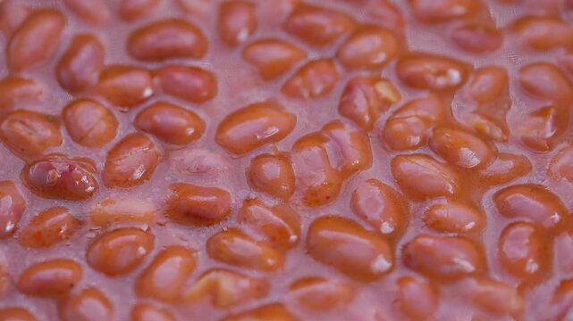 Stewed bean presentation, Juicy red beans in flavorful sauce, Close shot of beans in savory tomato glaze, Brightly glazed baked beans immersed in rich tomato sauce for display