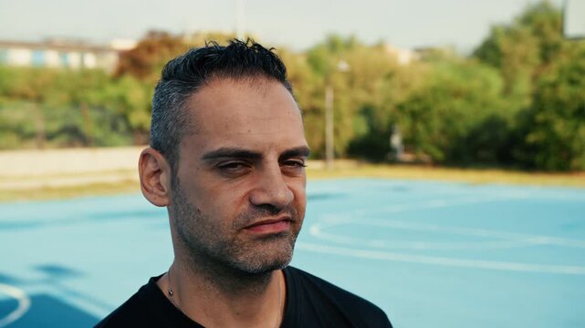 man with a defiant look on a basketball court
