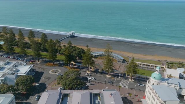 Aerial view of Marine Parade, Napier, New Zealand, showcasing the scenic waterfront, black sand beach, and iconic architecture. A popular destination for tourists and locals alike.