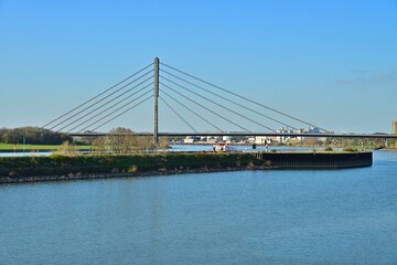 Fototapeta premium Modern cable stayed bridge over wide river in industrial landscape