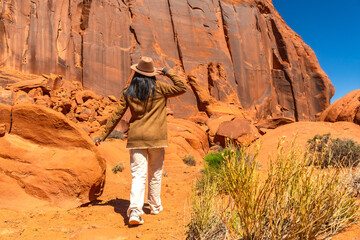 Naklejka premium Woman exploring monument valley desert landscape under blue sky