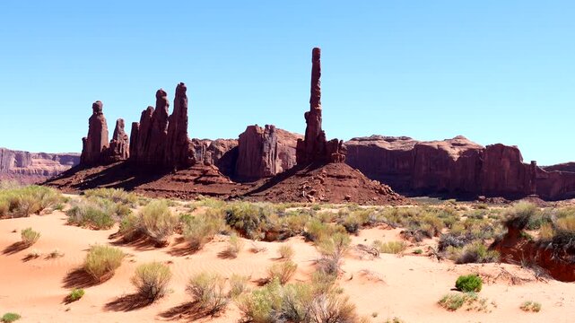 Iconic totem pole butte and sandstone formations standing tall in the arid desert landscape of monument valley tribal park on the arizona utah border, a renowned tourist destination