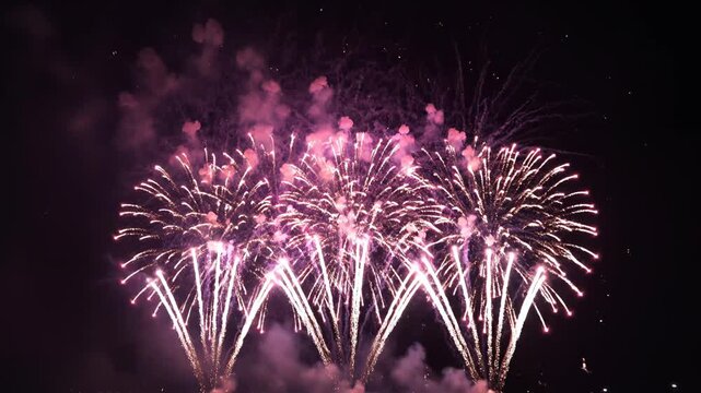 Pink fireworks exploding in night sky emphasizing sleek aesthetics and strong visual impact