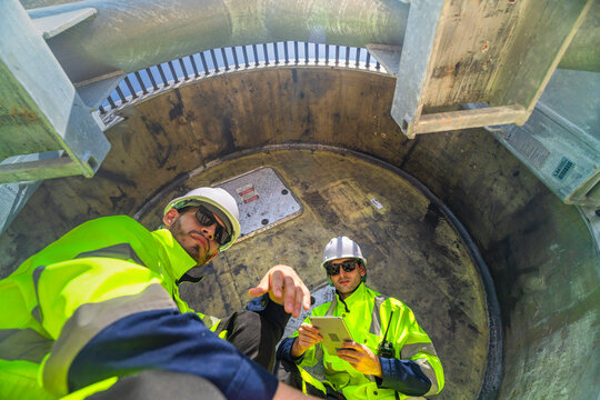 Technical wind turbine specialists performing an internal inspection of the nacelle and pitch system components at a renewable energy facility.