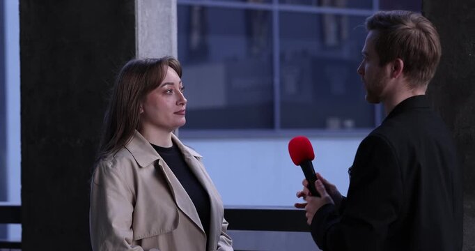 Professional journalist with microphone interviewing woman outdoors