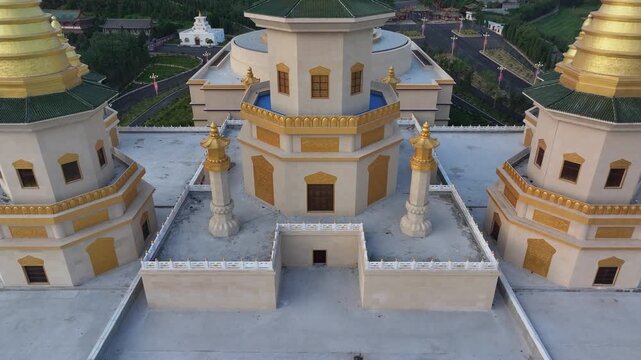 Aerial view of golden pagoda complex with traditional Buddhist temple architecture and surrounding mountain landscape