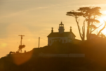 Sunset light illuminates a historic lighthouse and beach along the Pacific Ocean in Crescent City, California, USA. © Matt Gush