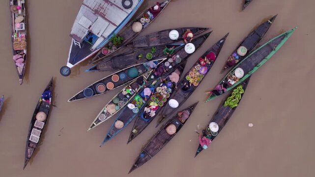 Overhead view of a bustling Indonesian floating market with many wooden boats filled with vendors