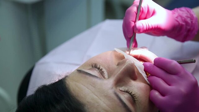 Female dentist curing a woman patient. Dental clinic and dentist appointment concept.