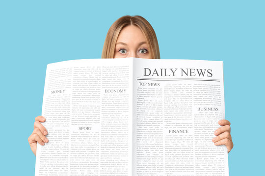 Shocked adult woman with newspaper on blue background