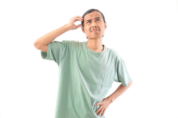 Fototapeta premium young handsome Indonesian, Asian man in green shirt confusion face and gesture isolated on white background. Feeling clueless and confused