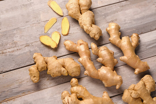 Fresh ginger roots on grey wooden background