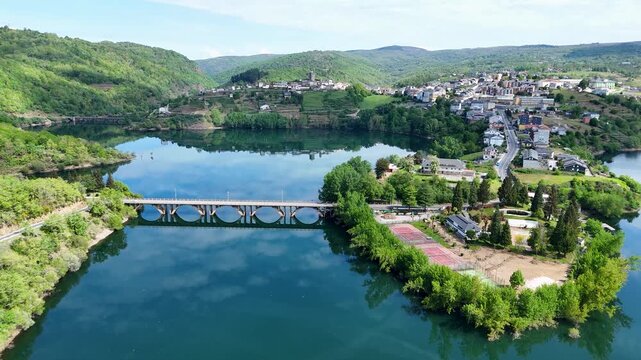 Aerial view of the town of Viana do Bolo on a peninsula surrounded by the reservoir with a bridge and lush green hills Viana do Bolo, Province of Ourense, Spain.