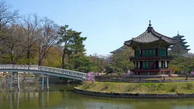 Horizontal panning footage of Gyeongbokgung palace pavilion with a bridge and pond in Seoul, South Korea