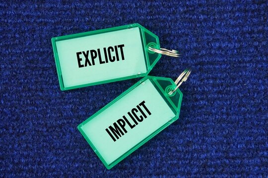 Plastic tag with the words explicit and implicit. Explicit &ndash; clearly stated so there is no room for confusion or questions. Implicit &ndash; implied or suggested, but not clearly stated.