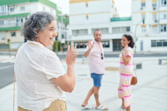 Senior woman greeting family meeting outdoors