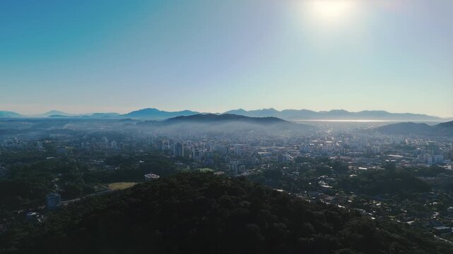 Aerial View of Joinville Cityscape with Forested Hill and Mountains in Brazil