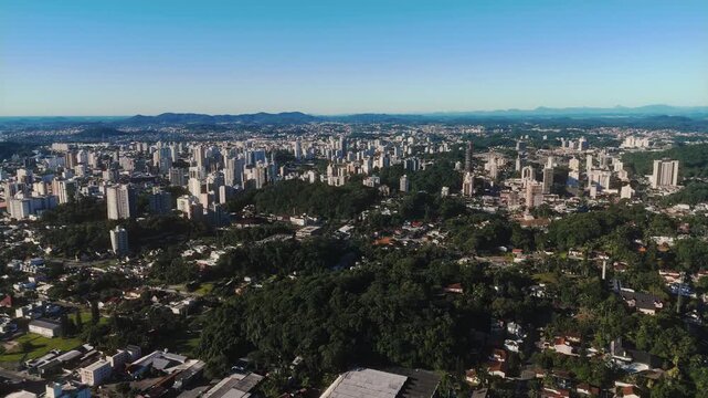 Aerial View of Joinville Cityscape with Forested Hill and Mountains in Brazil