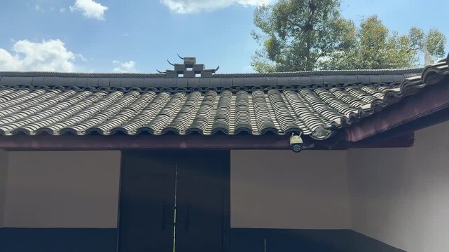 Chengdu, Sichuan/China - May 13 2026: A modern surveillance camera installed on the traditional grey tiled roof of the historic Zhu Xi Ancestral Hall.