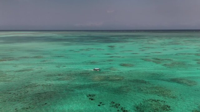 Cinematic footage of a boat sailing through crystal-clear turquoise waters above a vibrant coral reef in Africa. Stunning tropical seascape showcasing rich marine colors, calm ocean movement, and pris