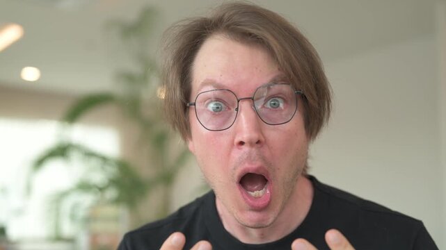 Portrait of shocked Scandinavian Northern European man face sitting in coffee shop cafe restaurant