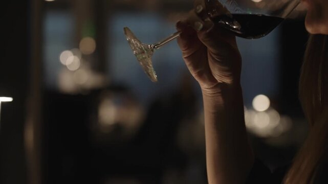 4K footage of a young woman enjoying red wine at a premium hotel, capturing upscale hospitality, refined dining atmosphere, and relaxed luxury lifestyle setting.