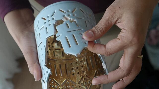 Close-up of Hand fixing the broken Light Blue decorative item