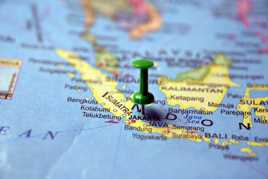 Green Push Pin Marking Jakarta on Paper World Map Macro Close Up with Blurred Background